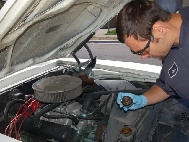 Mechanic inspecting a car engine; open hood, blue gloves, focus on a cap, outside setting.